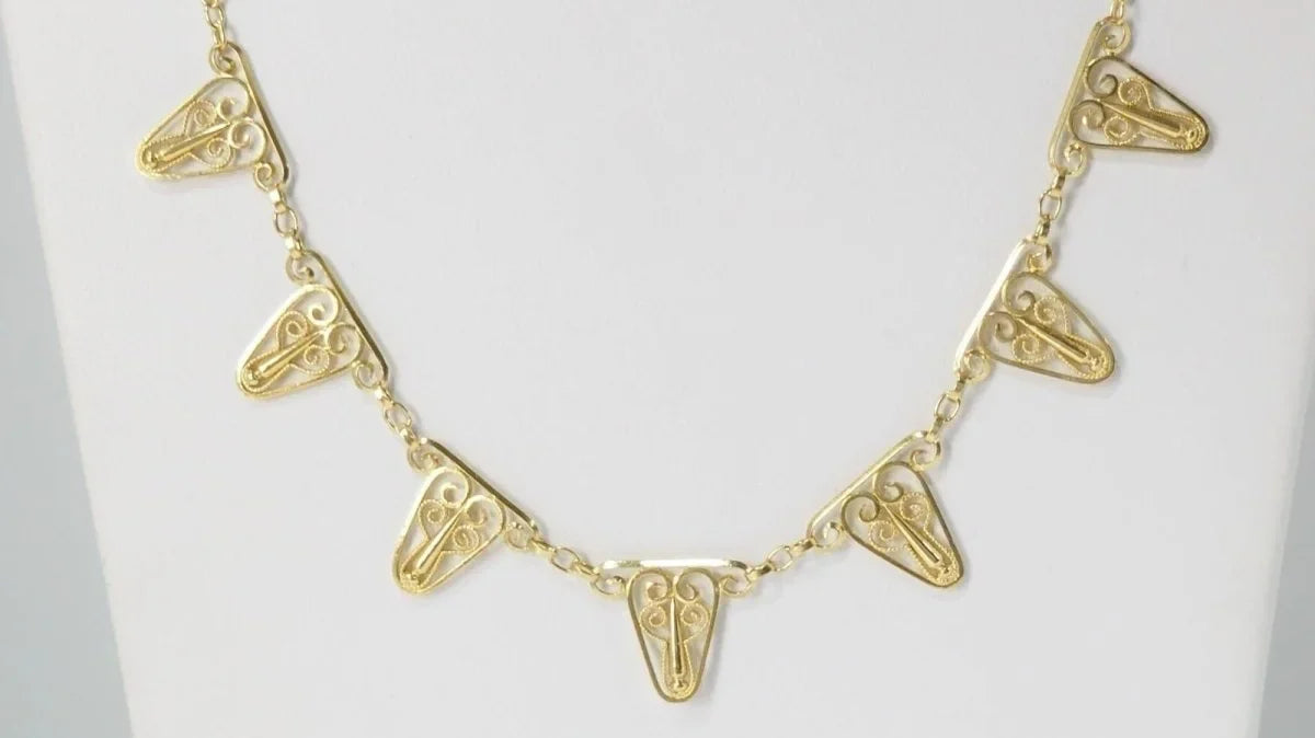 Gold tooth necklace with intricate designs from Leisure Tapis Chien Teckel collection