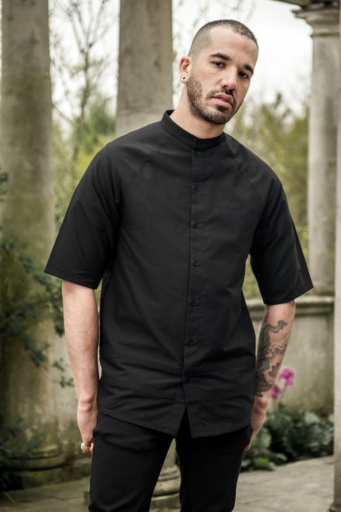 Black short-sleeved chef’s jacket with button-down front and mandarin collar for a Tes product