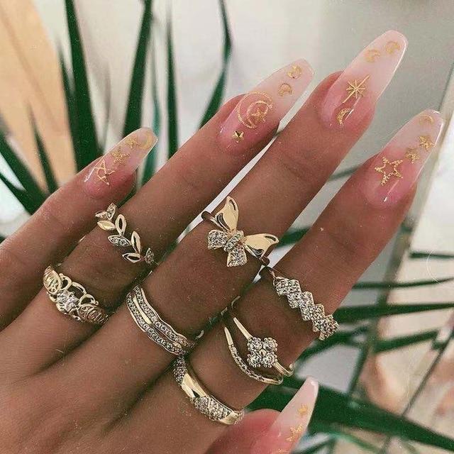 Gold star and butterfly nail art on clear acrylic nails for stylish manicure designs