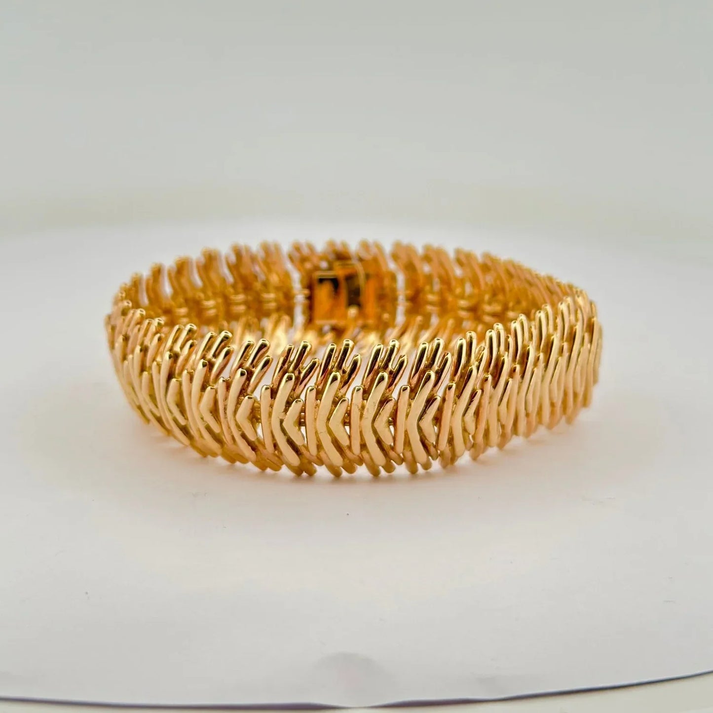 Gold textured bangle bracelet with clasp closure for stylish clothing accessories