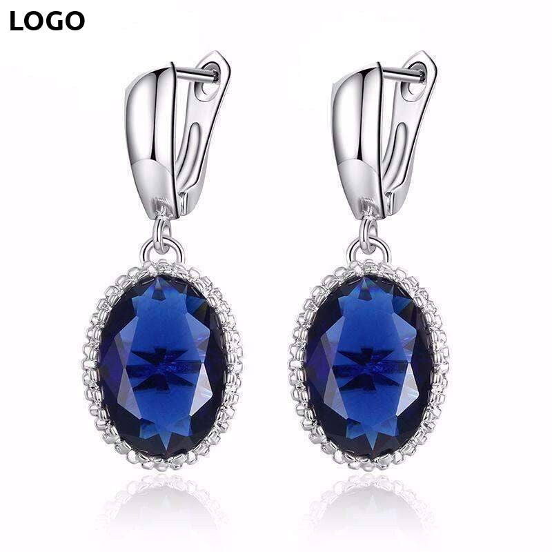 Silver drop earrings with large blue gemstones and white accents from Zip Product