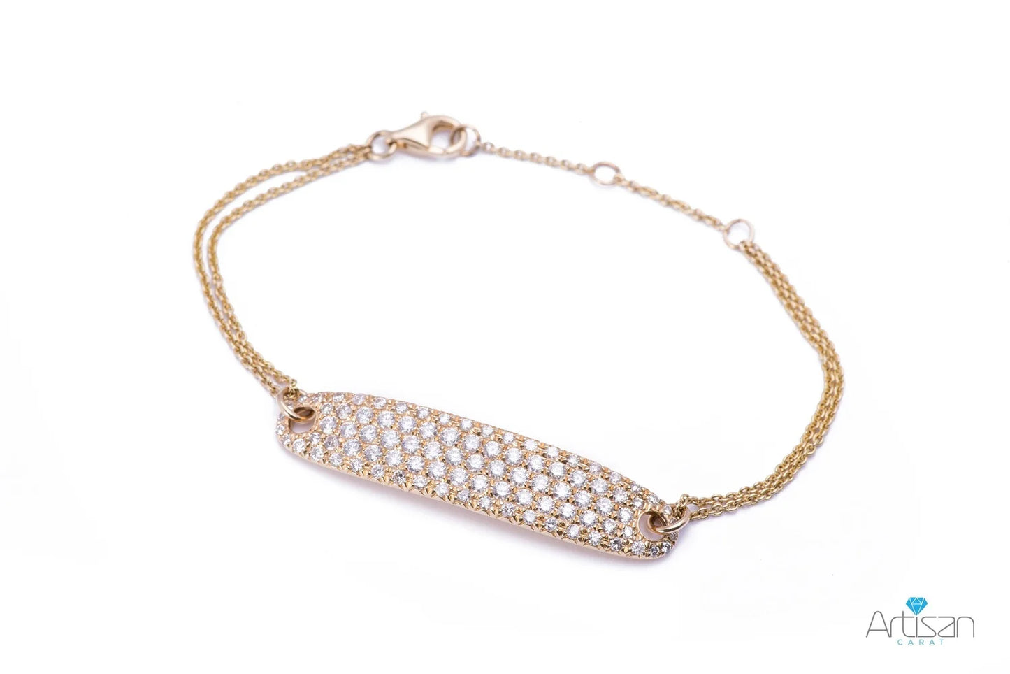 A gold toned delicate bracelet with a rectangular pave set diamond plaque and an intricate double chain design