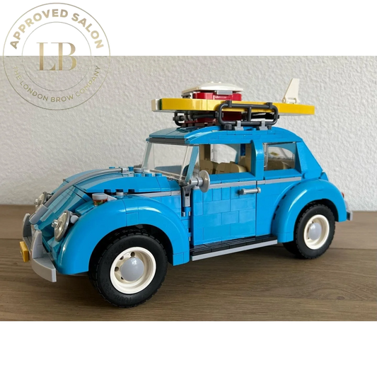 Blue lego volkswagen beetle with a yellow surfboard and red-and-white accessories on its roof rack