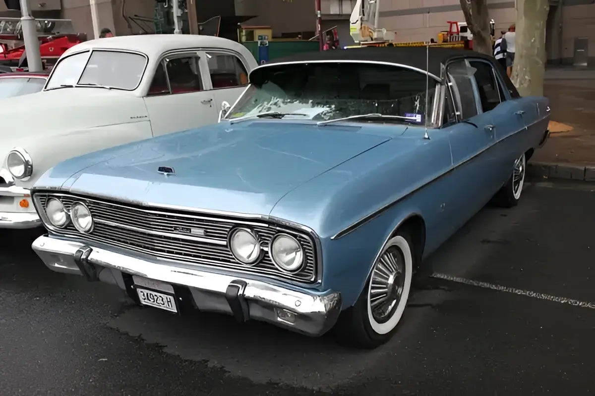 A light blue 1960s ford fairlane with white-walled tires featured in a valentine’s day pink heart bagels test
