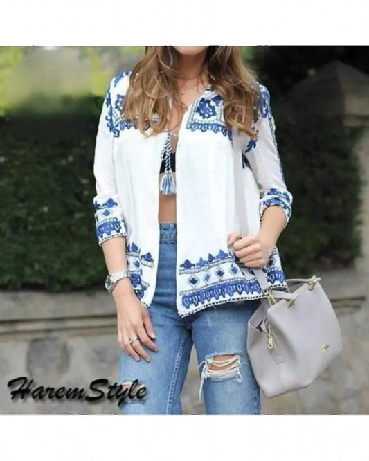 White embroidered jacket with blue patterns on collar, cuffs, hem